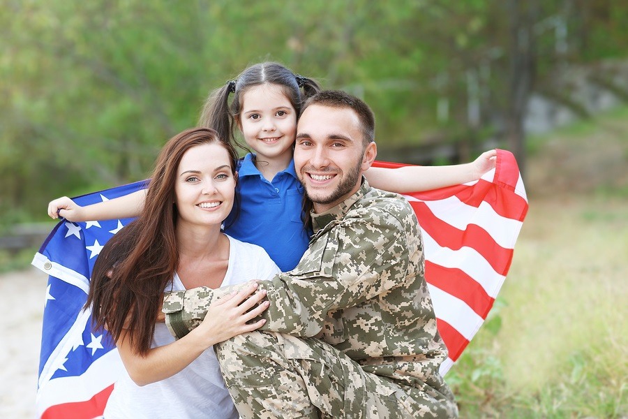US army soldier with family and USA flag in park