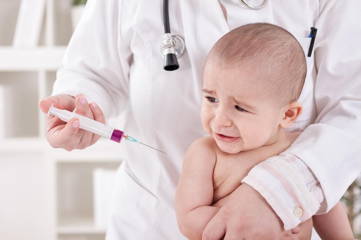 Crying little baby boy receive vaccine in office