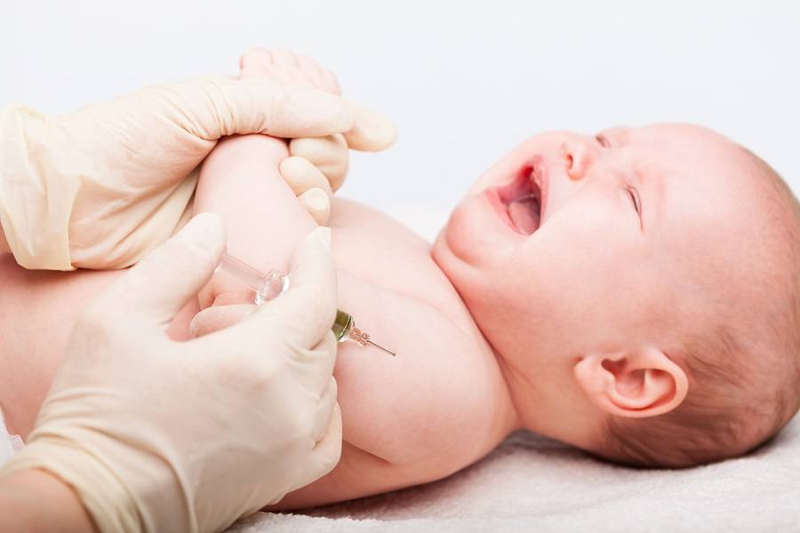 Close-up shot of pediatrician giving a three month baby girl  intramuscular injection in arm