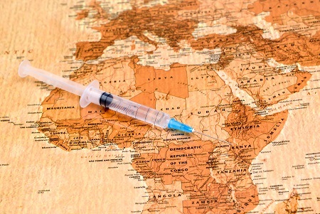 Photo of syringe on a map of Africa, antique style.