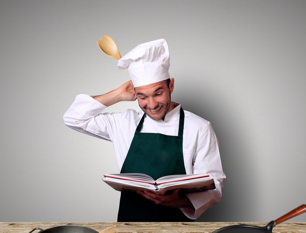 Chef in the kitchen with recipe book
