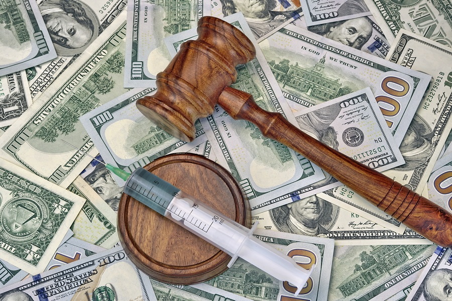 Wood Judges Gavel And Medical Syringe With Injection On The Dollar Cash Background Overhead View 