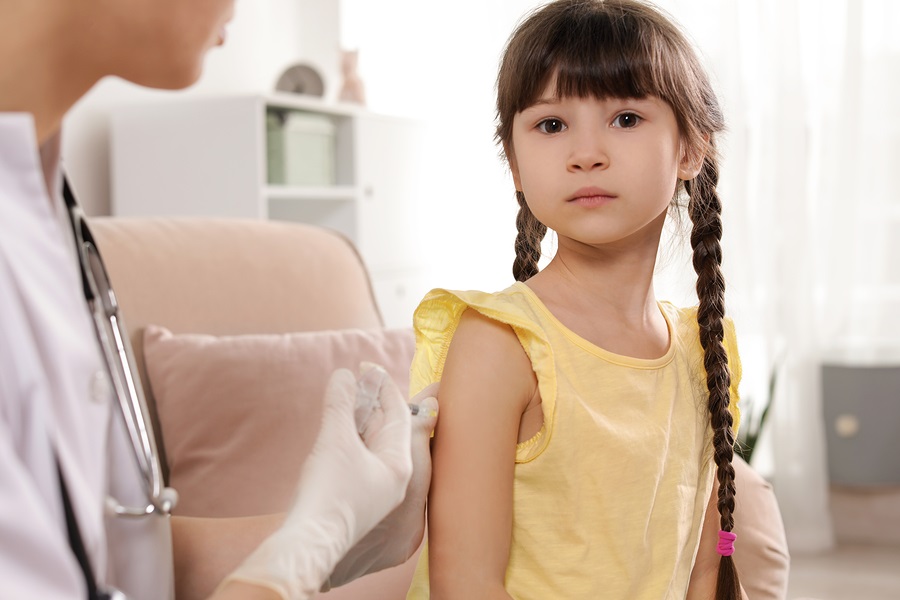 Doctor vaccinating young girl photo